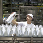 Homme chaine de bouteilles de lait usine
