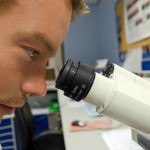 Gros plan d'homme regardant dans microscope, laboratoire