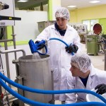 Deux jeunes étudiants remplissent d'eau une cuve