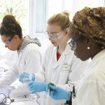 Trois lycéennes faisant expérience en laboratoire, pipette, éprouvette