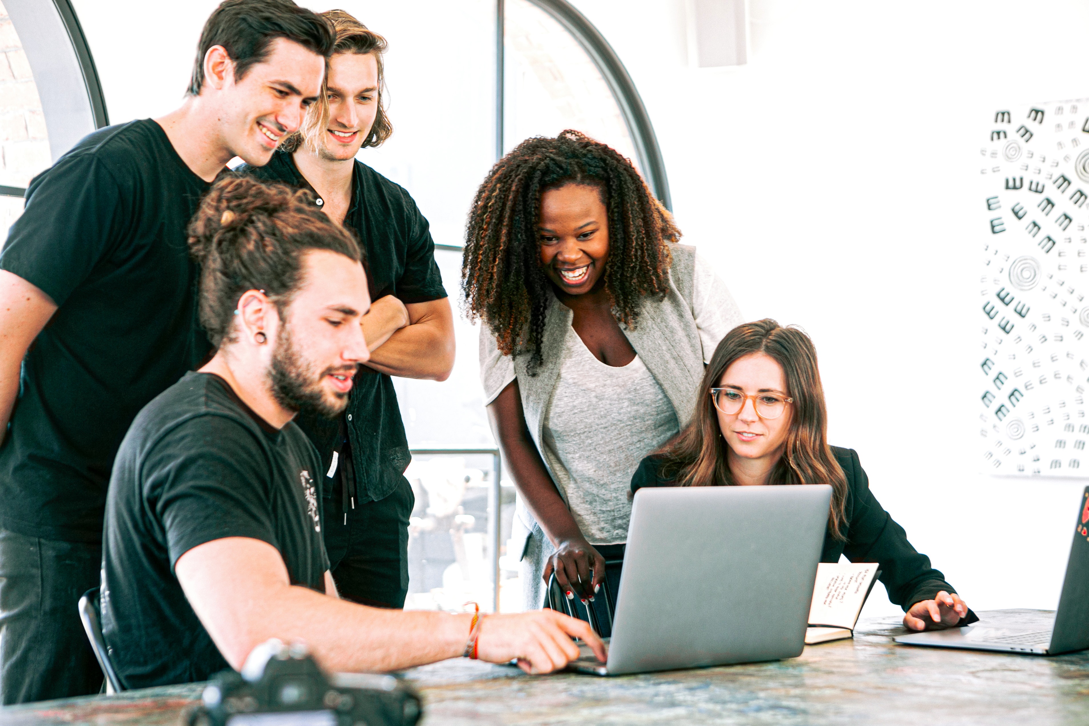 Groupe de jeunes regardant ordinateur, formation, rire, bureau